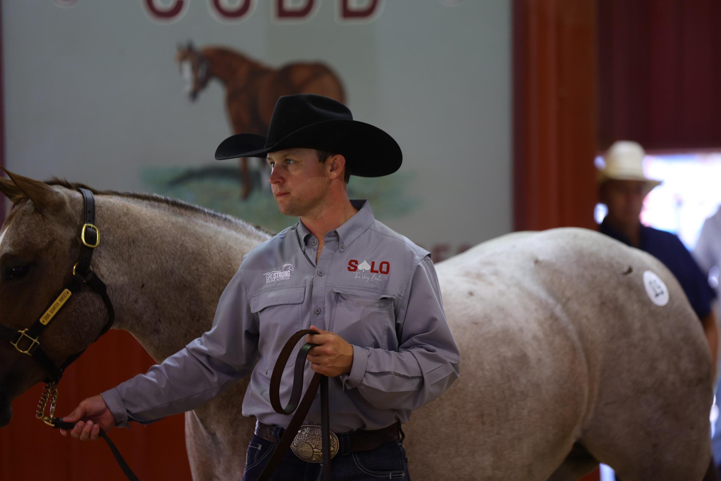 A Solo Select handler in a Solo shirt presenting a roan horse in hand at the sale